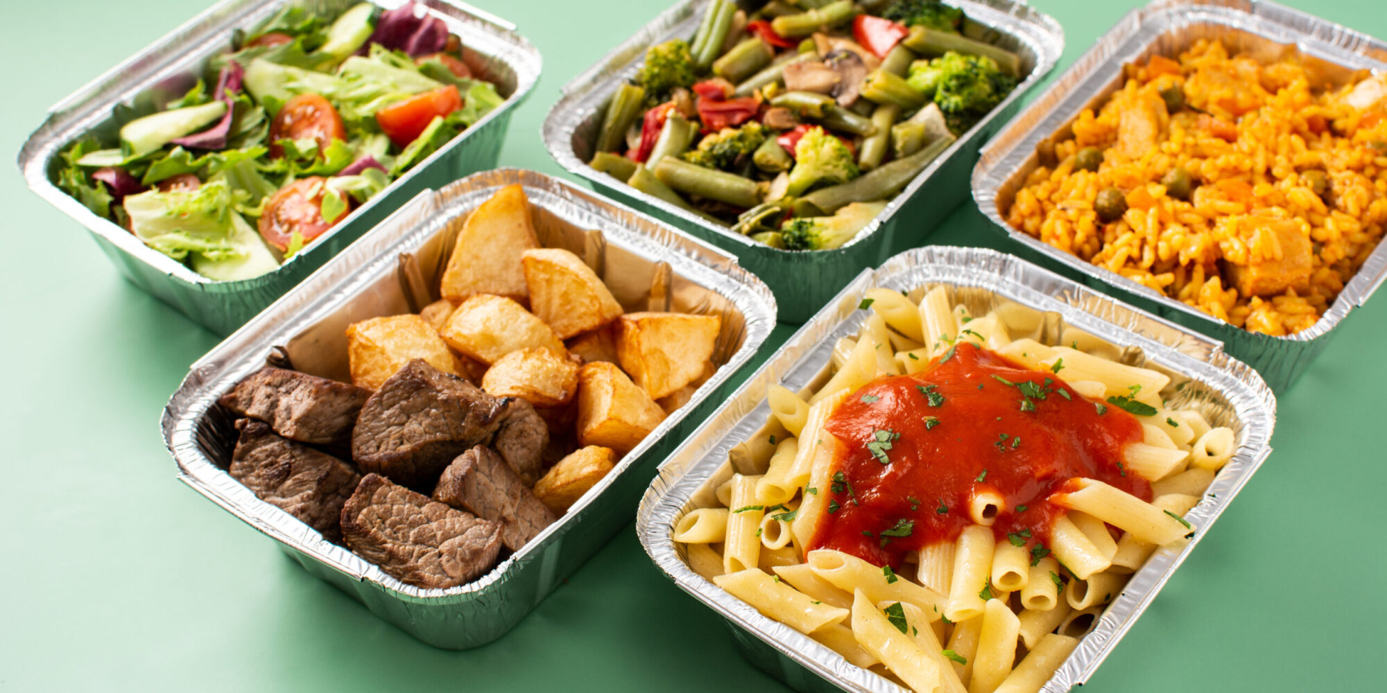 Take,Away,Healthy,Food,In,Foil,Boxes,On,Green,Background